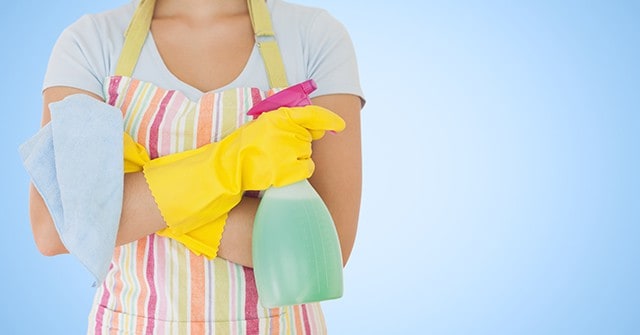 Mid section of female cleaner with spray bottle