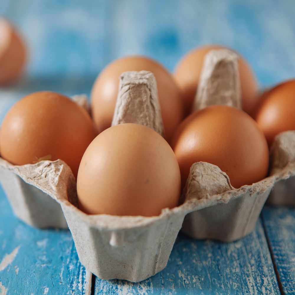 Eggs in a carton on a shaby chic teal table