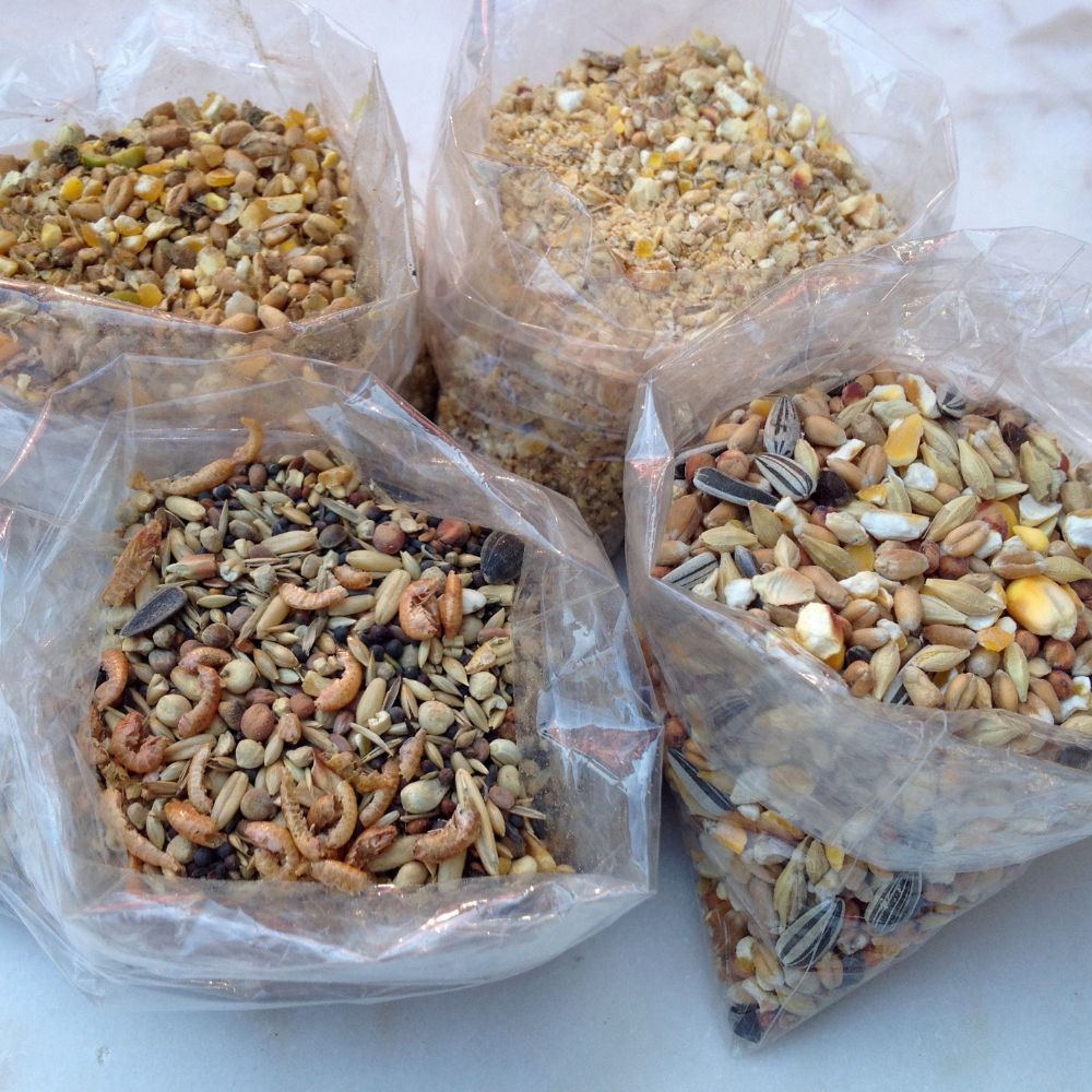 Four bags of different kinds of chicken feed